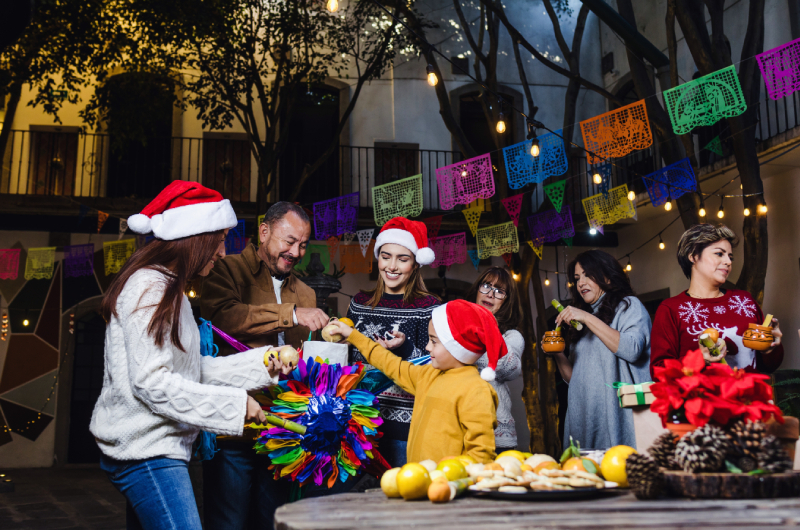 familia mexicana rompiendo piñata en cena navideña